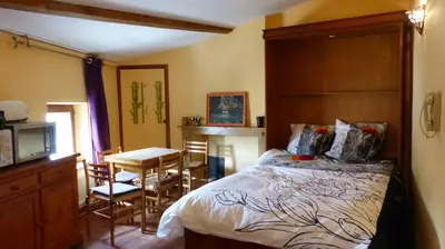 a bedroom with a bed and a table and chairs at Le Minervois in Carcassonne
