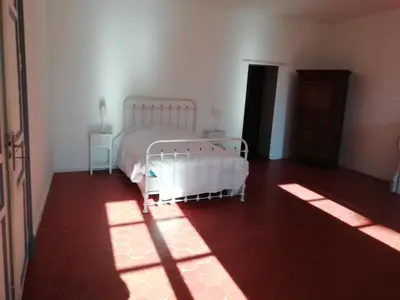 a bedroom with a bed in a room with sunlight at Les Colonnades in Moussan