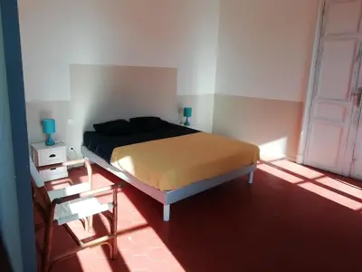 a bedroom with a bed and a door at Les Colonnades in Moussan