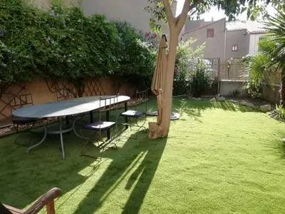 a table and a umbrella and a tree in a yard at Les Colonnades in Moussan