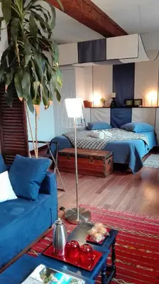 a bedroom with a bed and a blue couch at Maison d'hôte la Tourette in Cucugnan