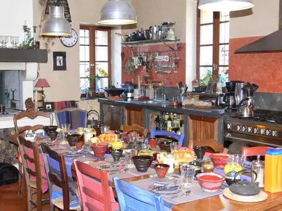 a kitchen with a long table with dishes on it at Maison d'hôte la Tourette in Cucugnan
