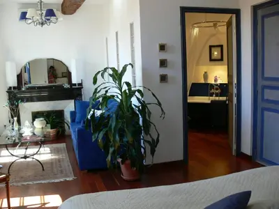 a living room with a blue door and a plant at Maison d'hôte la Tourette in Cucugnan