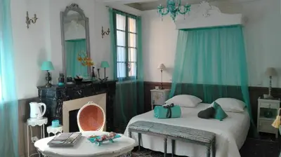 a bedroom with a bed and a table and a mirror at Maison d'hôte la Tourette in Cucugnan