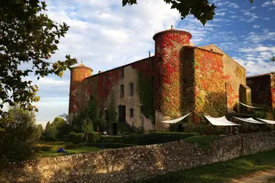 a tennis court with a net in a field at Château de Villarlong in Villarzel-Cabardès