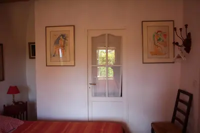 a bedroom with a door and a window and a bed at Sous l'abricotier in Durban-Corbières