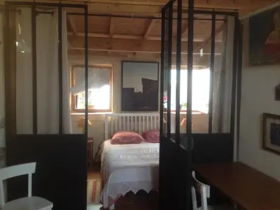 a bedroom with a bed and two windows at Sous l'abricotier in Durban-Corbières