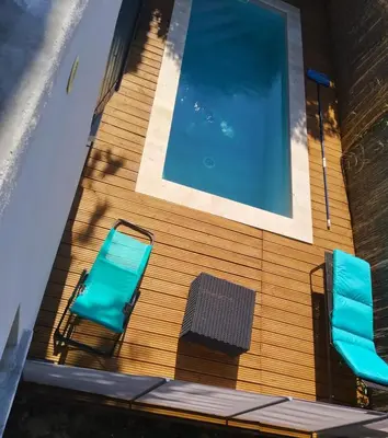 two chairs and a sign on the side of a building at Les lauriers roses & sa piscine privative in Narbonne