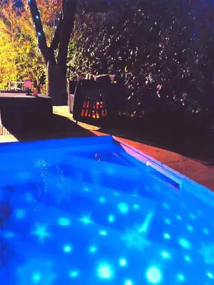a blue swimming pool in a park at night at Les lauriers roses & sa piscine privative in Narbonne