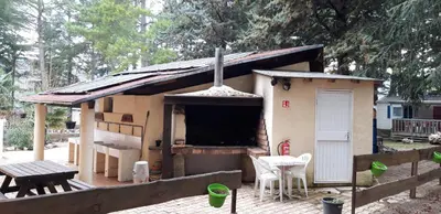 a small house with a grill and a table at Camping la Source in Sournia
