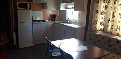 a kitchen with a wooden table and a table and chairs at Camping la Source in Sournia
