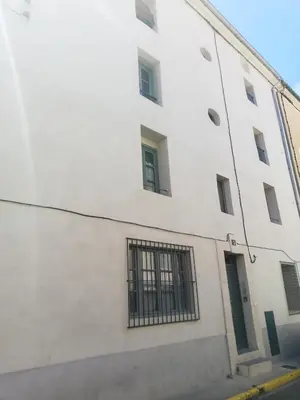 a white building with barred windows on a street at T2 Cozy proche des Halles Climatisé in Narbonne
