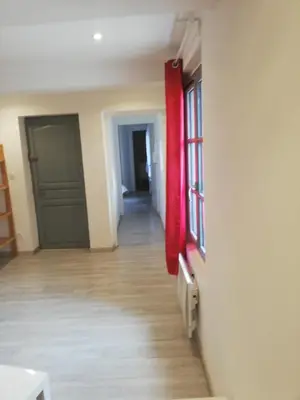 an empty room with a red door and a hallway at T2 Cozy proche des Halles Climatisé in Narbonne