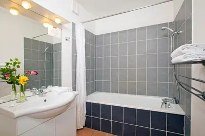 a bathroom with a white tub and a sink and a bath tubermott at Cerise Carcassonne Sud in Carcassonne