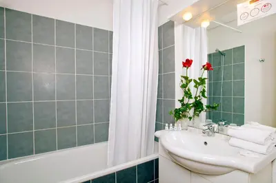 a bathroom with a sink and a shower and a tub at Cerise Carcassonne Sud in Carcassonne