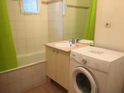 a bathroom with a washing machine and a sink at Les iris in Carcassonne