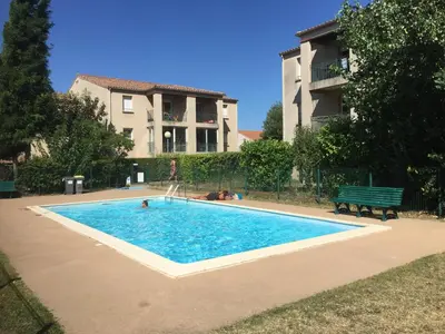 a swimming pool in front of a house at Les iris in Carcassonne