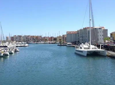 a white fence around a swimming pool in front of a building at Perle méditerranéenne au coeur du port de Gruissan in Gruissan