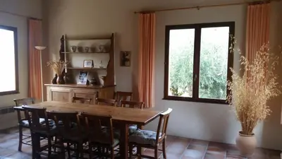 a dining room with a wooden table and chairs at Le Cers in Ribaute
