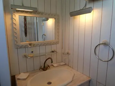 a bathroom with a sink and a mirror at UN CHALET EN BOIS A LA PLAGE in Gruissan