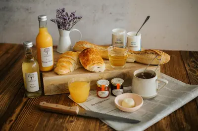 a table with bread and drinks and bottles of orange juice at La Terrasse de Jules in Carcassonne