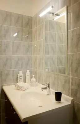 a bathroom with a sink and a mirror at La Terrasse de Jules in Carcassonne