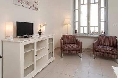 a living room with a tv and two chairs at La Terrasse de Jules in Carcassonne