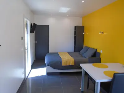 a bedroom with a bed and a table in it at Studio les trois chemins in Cucugnan