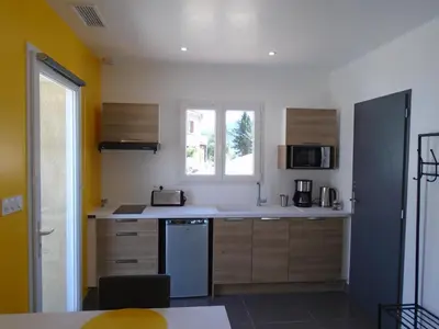 a kitchen with a white counter and a window at Studio les trois chemins in Cucugnan