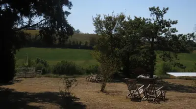 a group of chairs and trees in a field at Nature's Pace Holidays in Montmaur