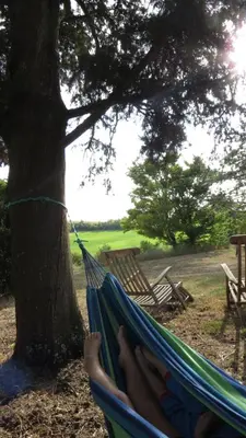 a person laying in a hammock under a tree at Nature's Pace Holidays in Montmaur