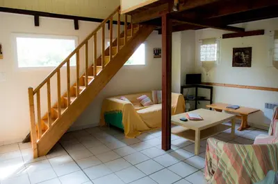 a living room with a staircase and a table at Nature's Pace Holidays in Montmaur