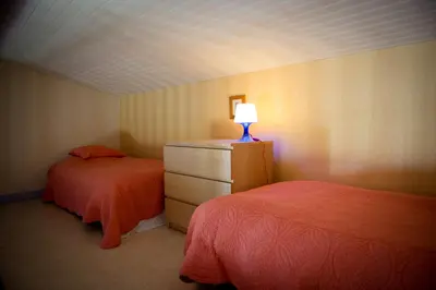 a bedroom with two beds and a dresser with a lamp at Nature's Pace Holidays in Montmaur