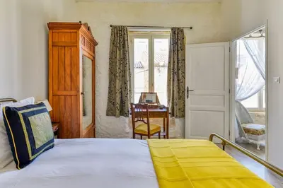 a bedroom with a bed and a window and a desk at La Calade in Montouliers