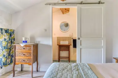 a bedroom with a bed and a dresser and a mirror at La Calade in Montouliers