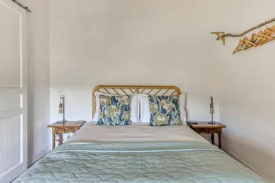 a bedroom with a bed with pillows and two tables at La Calade in Montouliers