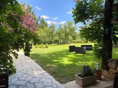 a garden with two benches in the grass at Hameau de Montcabirol - Pyrénées in Mirepoix
