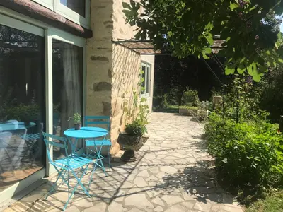 a patio with a blue table and chairs next to a building at Hameau de Montcabirol - Pyrénées in Mirepoix