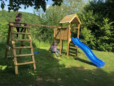 a little girl playing on a playground with a slide at Hameau de Montcabirol - Pyrénées in Mirepoix