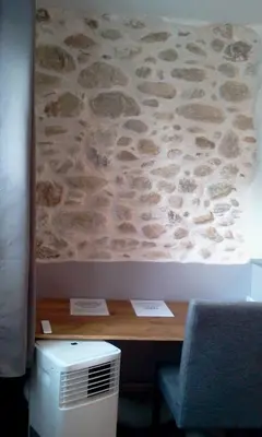 a room with a desk with a stone wall at Maison de ville au pied de la Montagne Noire in Mazamet