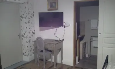 a room with a desk with a television on a wall at Maison de ville au pied de la Montagne Noire in Mazamet