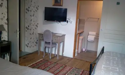 a bedroom with a desk and a television on the wall at Maison de ville au pied de la Montagne Noire in Mazamet