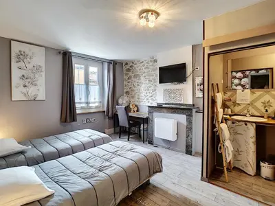 a hotel room with two beds and a desk at Maison de ville au pied de la Montagne Noire in Mazamet