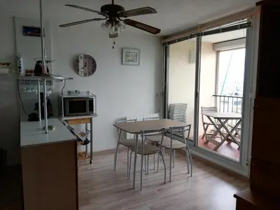 a kitchen and dining room with a table and chairs at T2 sur le port avec parking in Gruissan