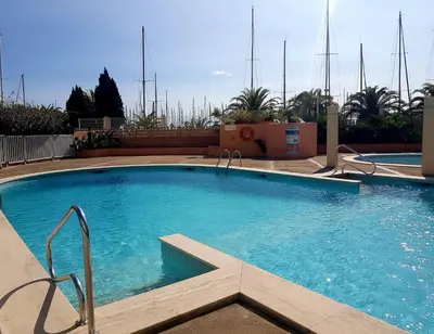 a large swimming pool with blue water at T2 sur le port avec parking in Gruissan