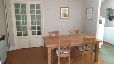 a kitchen with a wooden table and chairs at chez Black and White in Les Martys