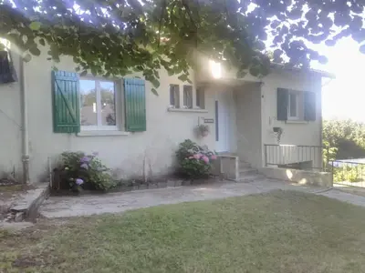 a white house with green windows and flowers at chez Black and White in Les Martys