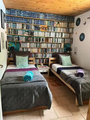 two beds in a room with a book shelf at Appartement Climatisé T3 Piscine et Parking in Pennautier