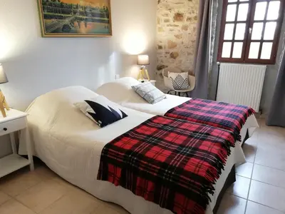 a bedroom with a bed with a plaid blanket on it at Domaine des Goudis in Bouisse