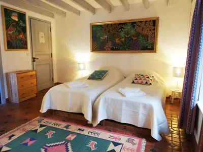 a bedroom with two beds and a painting on the wall at Domaine des Goudis in Bouisse